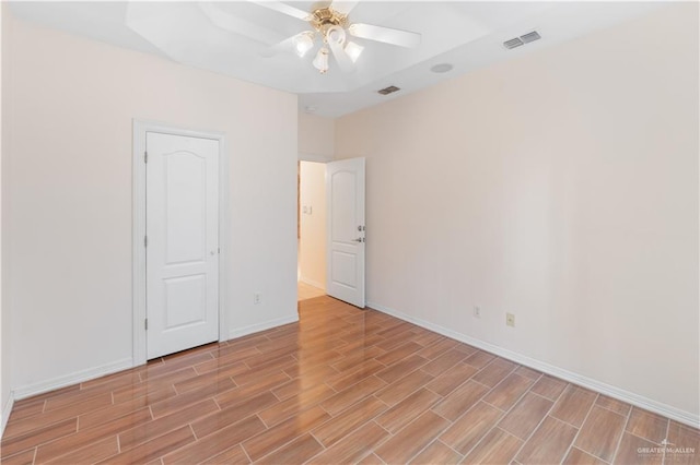 unfurnished bedroom featuring baseboards, a ceiling fan, visible vents, and wood tiled floor