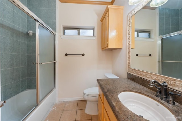 bathroom featuring baseboards, bath / shower combo with glass door, toilet, tile patterned floors, and vanity