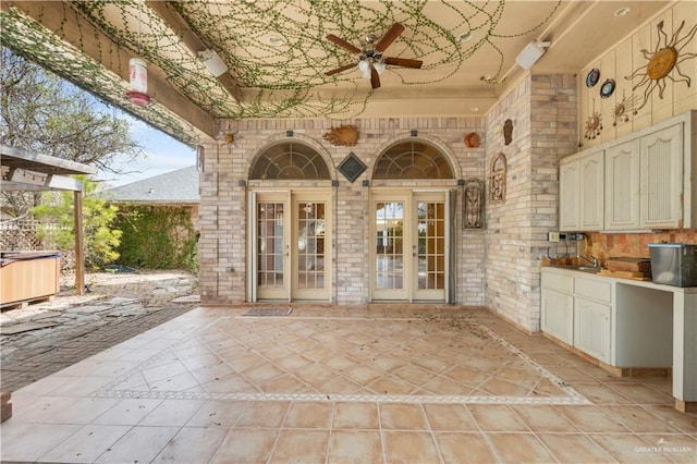 view of patio featuring an outdoor kitchen, a ceiling fan, and french doors