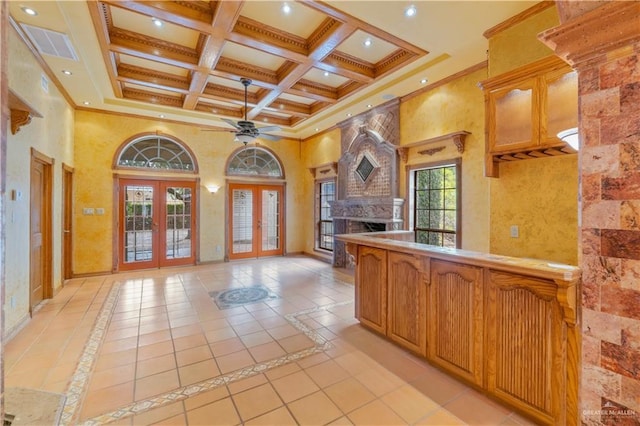 kitchen with plenty of natural light, french doors, a fireplace, and a high ceiling