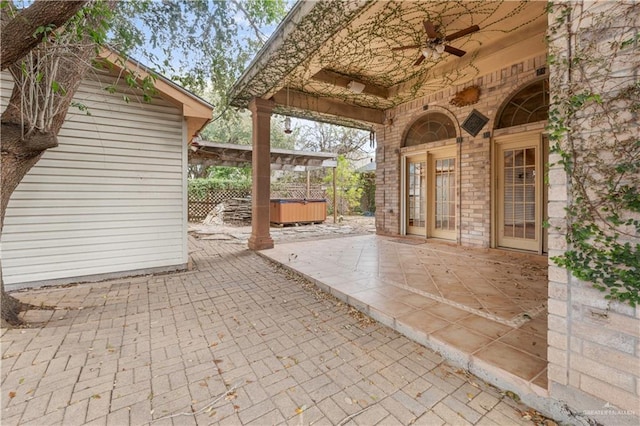 view of patio with french doors, a ceiling fan, and a hot tub