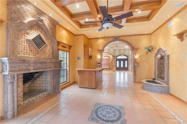 interior space with a high ceiling, visible vents, a premium fireplace, and arched walkways