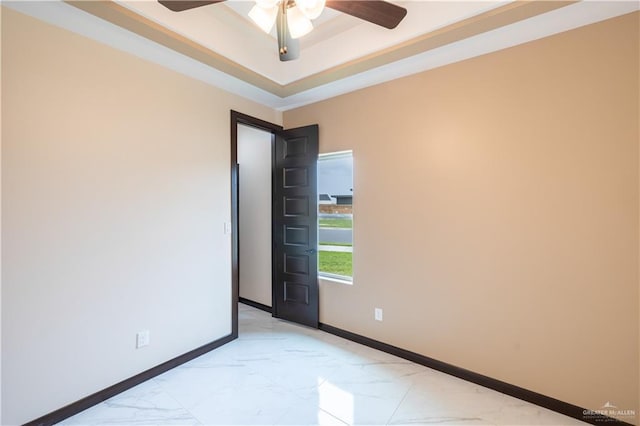 3812 Santa Fe St, Edinburg, TX 78542 - spare room with light marble finish floors, ceiling fan, baseboards, and a tray ceiling