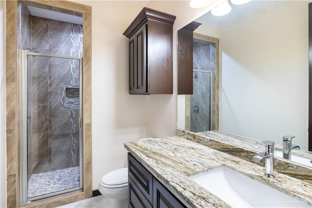 bathroom featuring vanity, toilet, and a shower with shower door