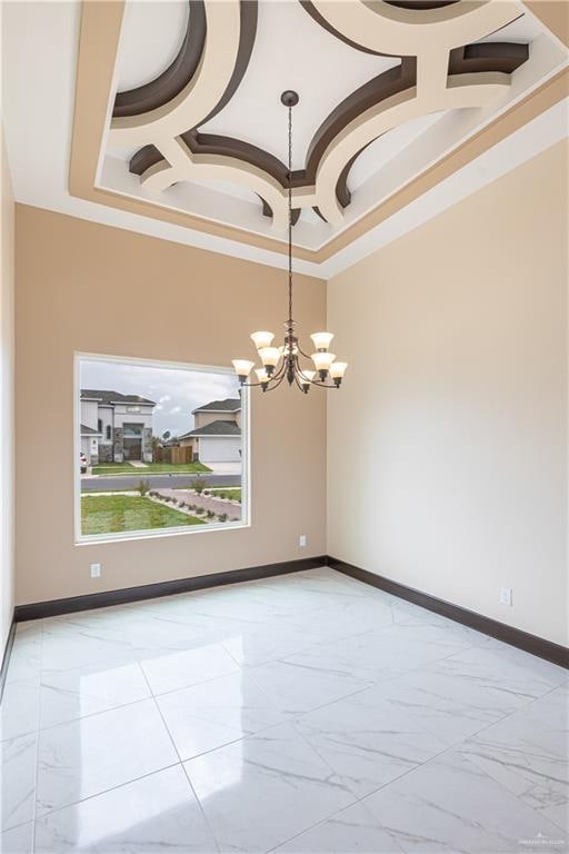 unfurnished room with a tray ceiling, ornamental molding, coffered ceiling, and a notable chandelier