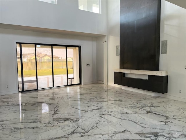 unfurnished living room featuring a high ceiling