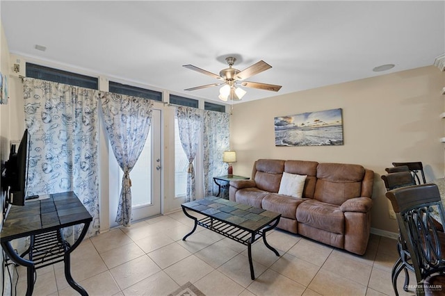 living area with a ceiling fan and light tile patterned floors