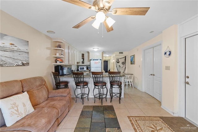 living room with light tile patterned floors and ceiling fan