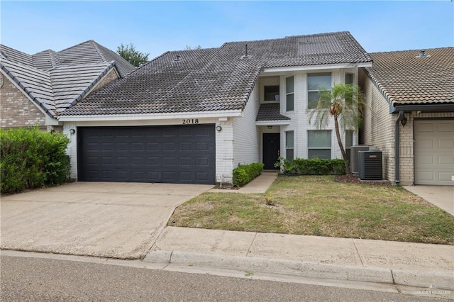 2018 Sabinal St, Mission, TX 78572 - view of front of property featuring a tiled roof, a garage, central AC, brick siding, and driveway