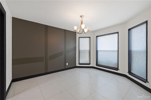 2018 Sabinal St, Mission, TX 78572 - empty room featuring light marble finish flooring, a chandelier, and baseboards