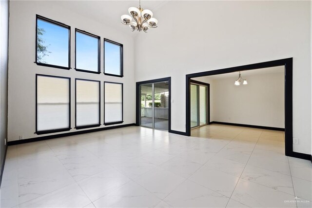 2018 Sabinal St, Mission, TX 78572 - unfurnished room featuring a chandelier, marble finish flooring, baseboards, and a towering ceiling
