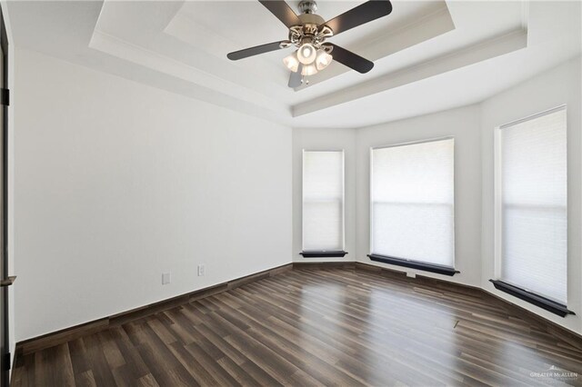 2018 Sabinal St, Mission, TX 78572 - unfurnished room featuring a raised ceiling, dark wood-type flooring, a ceiling fan, and baseboards