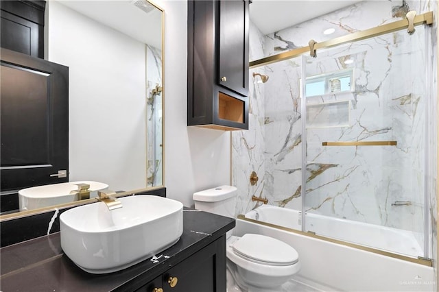 bathroom featuring toilet, vanity, and enclosed tub / shower combo