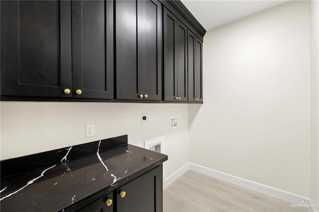 laundry area featuring cabinet space, light wood-type flooring, electric dryer hookup, washer hookup, and baseboards