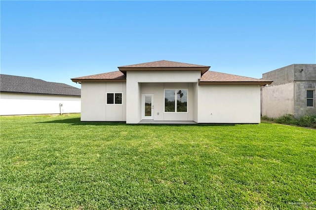 back of house featuring a yard and stucco siding