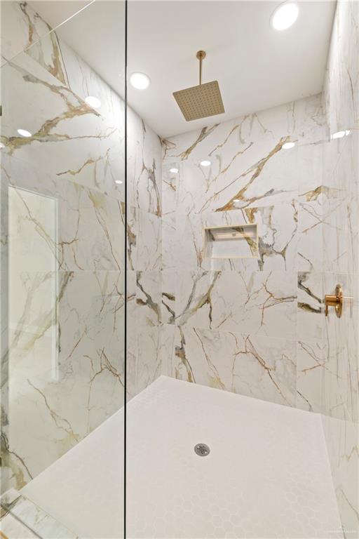 full bath with a marble finish shower and recessed lighting