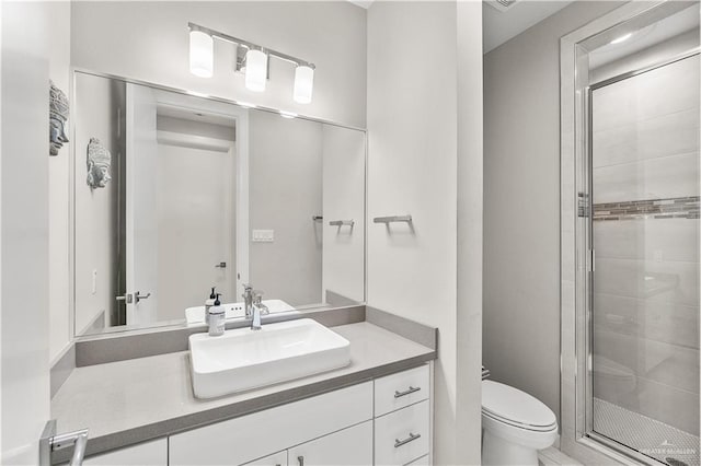 bathroom featuring vanity, toilet, and an enclosed shower