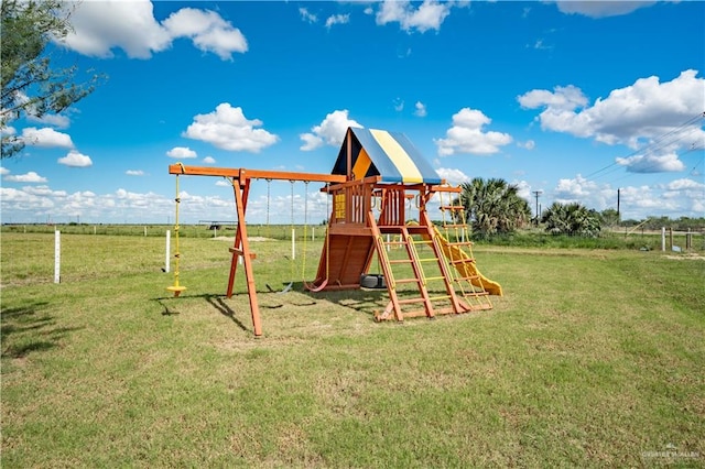 view of playground featuring a lawn and a rural view