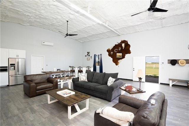 living room featuring hardwood / wood-style floors, a towering ceiling, and ceiling fan