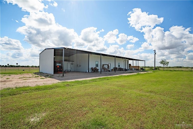 view of outdoor structure with a rural view and a yard