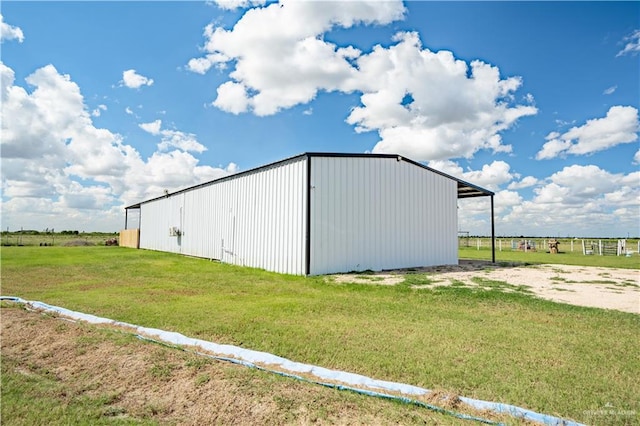 view of outbuilding with a rural view and a lawn