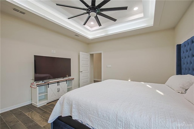 bedroom with a raised ceiling and ceiling fan