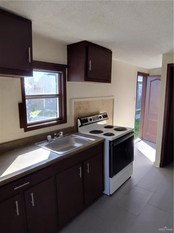 kitchen with white range with electric stovetop, dark brown cabinetry, sink, and a textured ceiling