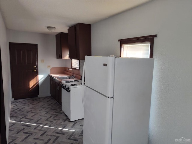 kitchen with sink, dark parquet floors, and white appliances