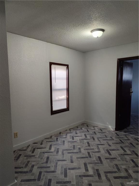 unfurnished room featuring carpet and a textured ceiling