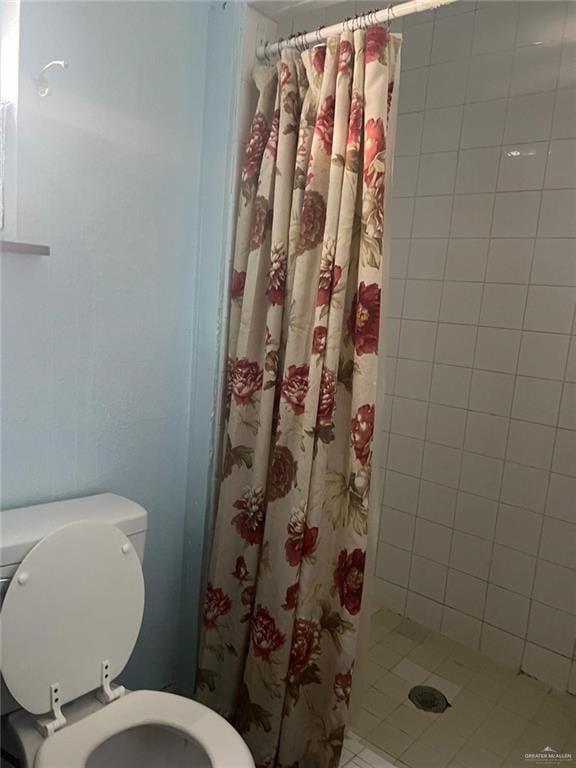 bathroom with a shower with curtain and toilet