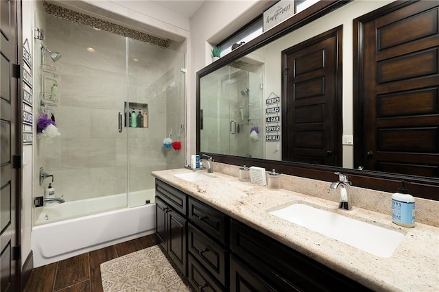 bathroom with combined bath / shower with glass door, hardwood / wood-style floors, and vanity