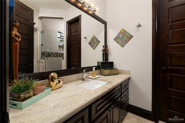 bathroom with tile patterned flooring, vanity, and tiled shower