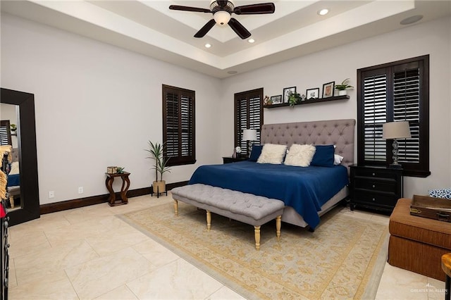 bedroom featuring a raised ceiling and ceiling fan