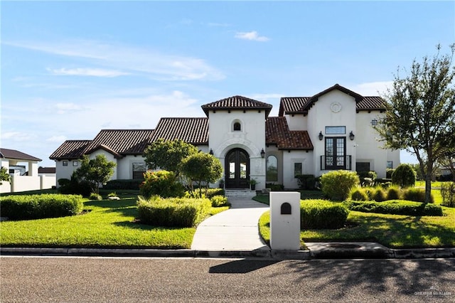 mediterranean / spanish-style home with french doors and a front lawn