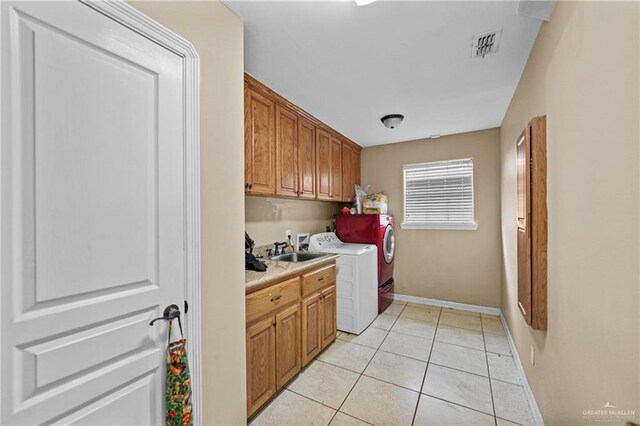 laundry area with light tile patterned flooring, cabinets, sink, and washing machine and dryer