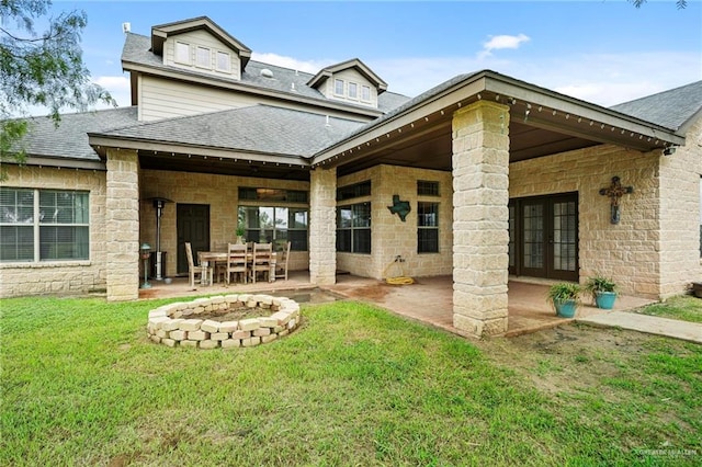 back of house with a fire pit, a yard, a patio, and french doors