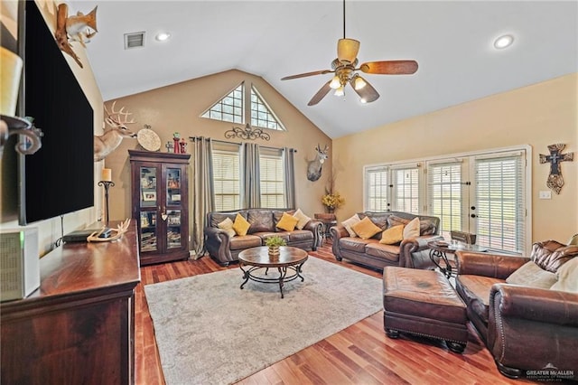 living room featuring ceiling fan, high vaulted ceiling, and light wood-type flooring