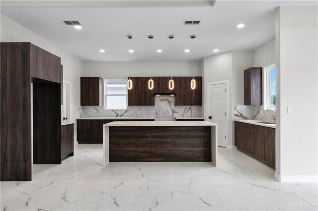 1013 N Buxton Ave, Edinburg, TX 78541 - kitchen with modern cabinets, tasteful backsplash, dark brown cabinets, a center island, and recessed lighting