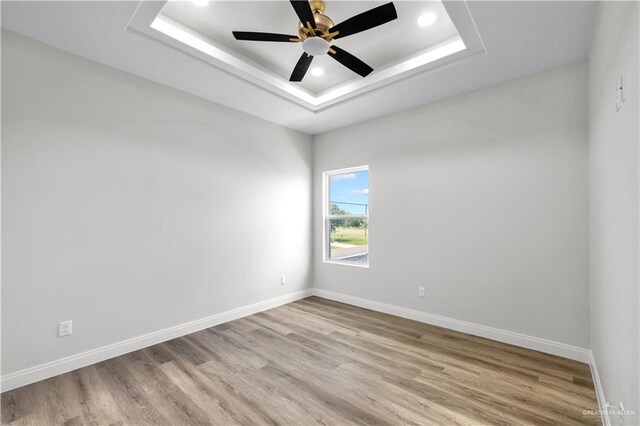 1013 N Buxton Ave, Edinburg, TX 78541 - empty room with a raised ceiling, light wood-style floors, a ceiling fan, baseboards, and recessed lighting
