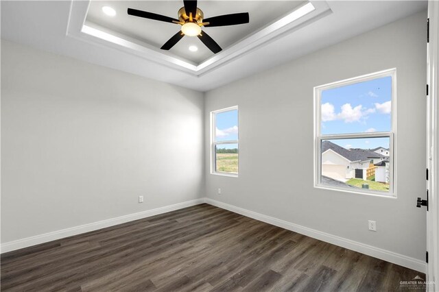 1013 N Buxton Ave, Edinburg, TX 78541 - unfurnished room with dark wood finished floors, baseboards, a ceiling fan, a raised ceiling, and recessed lighting
