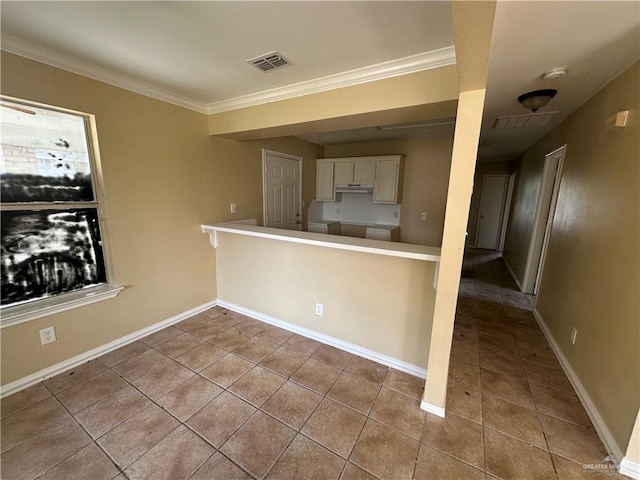 kitchen with crown molding, white cabinetry, kitchen peninsula, and light tile patterned floors