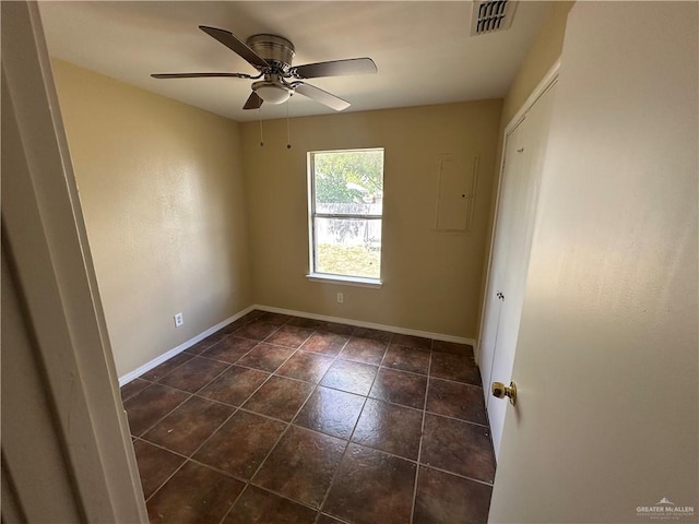 tiled spare room featuring electric panel and ceiling fan