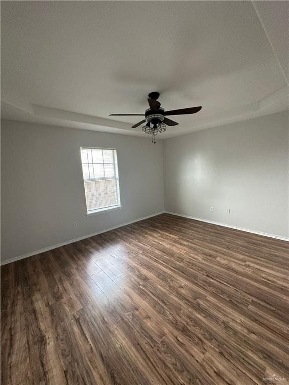 empty room featuring dark hardwood / wood-style flooring and ceiling fan