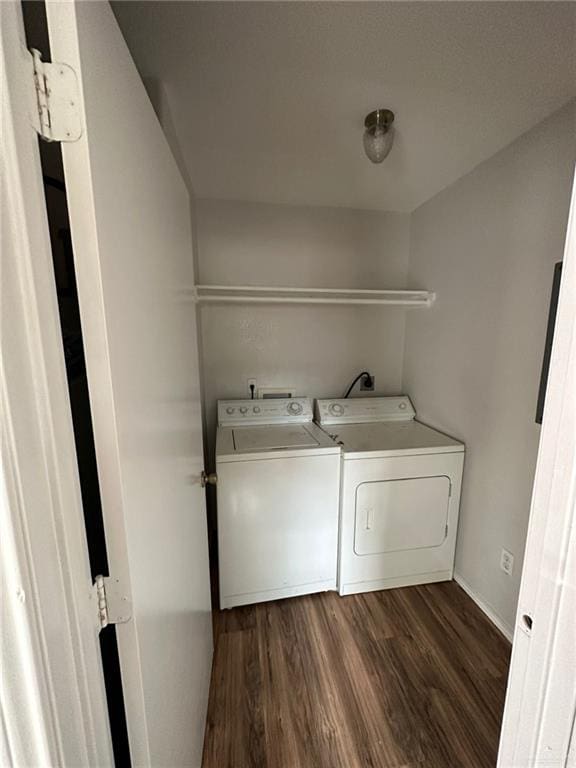 laundry area with washer and dryer and dark wood-type flooring