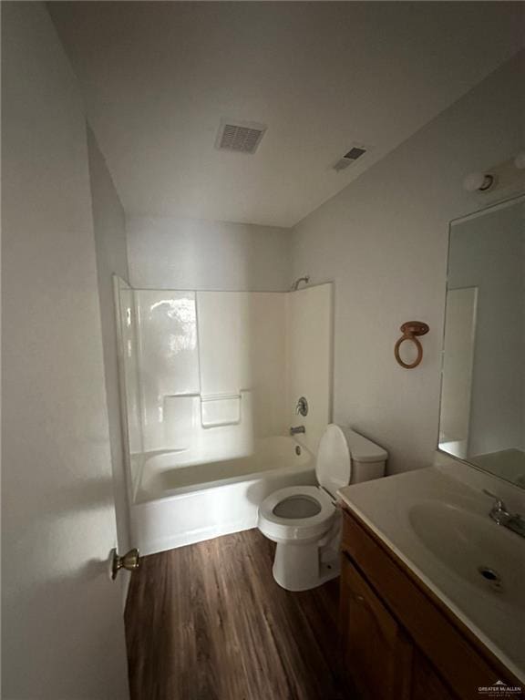 full bathroom featuring toilet, wood-type flooring, vanity, and bathing tub / shower combination