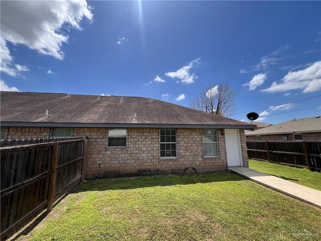 rear view of house featuring a yard