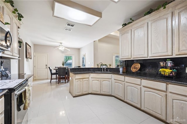 2005 E 28th St, Mission, TX 78574 - kitchen with appliances with stainless steel finishes, a peninsula, a ceiling fan, light tile patterned floors, and backsplash