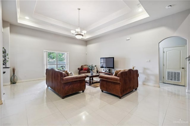 2005 E 28th St, Mission, TX 78574 - living room featuring a tray ceiling, a towering ceiling, arched walkways, light tile patterned floors, and a chandelier