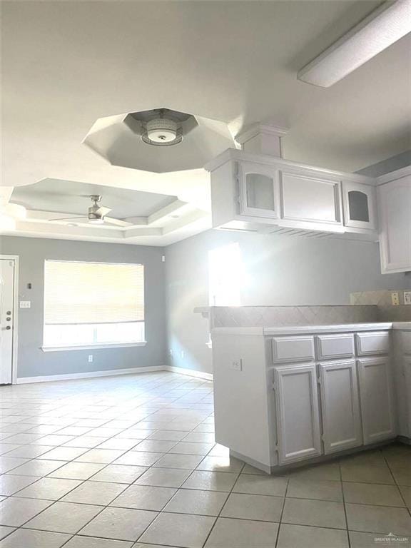 1706 Phoenix St, Edinburg, TX 78541 - kitchen featuring light tile patterned floors, light countertops, baseboards, and a raised ceiling