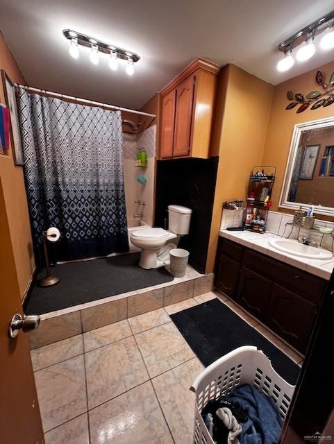 full bathroom featuring tile patterned flooring, vanity, shower / bath combo with shower curtain, and toilet